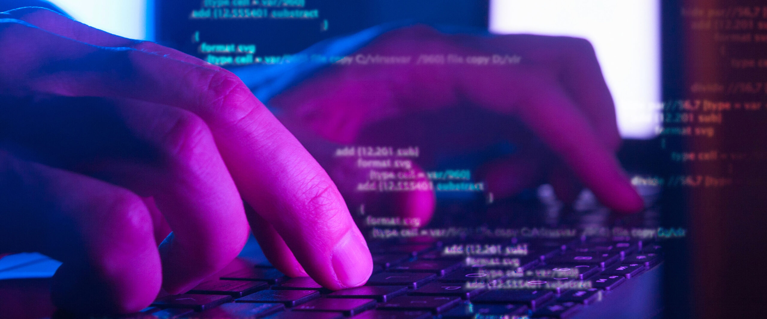 Close-up of hands typing on a keyboard with glowing blue and purple lighting; lines of computer code are superimposed, suggesting programming, cybersecurity, or IoT development.